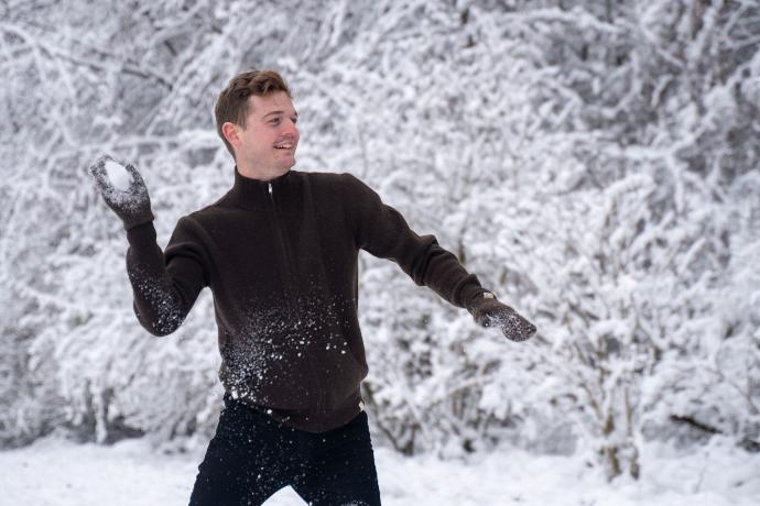 Modell in weißer Schneelandschaft trägt dunkelbraune Handschuhe aus Yakwolle