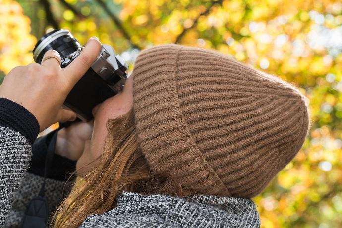 Model mit brauner Mütze aus Kamelwolle fotografiert.