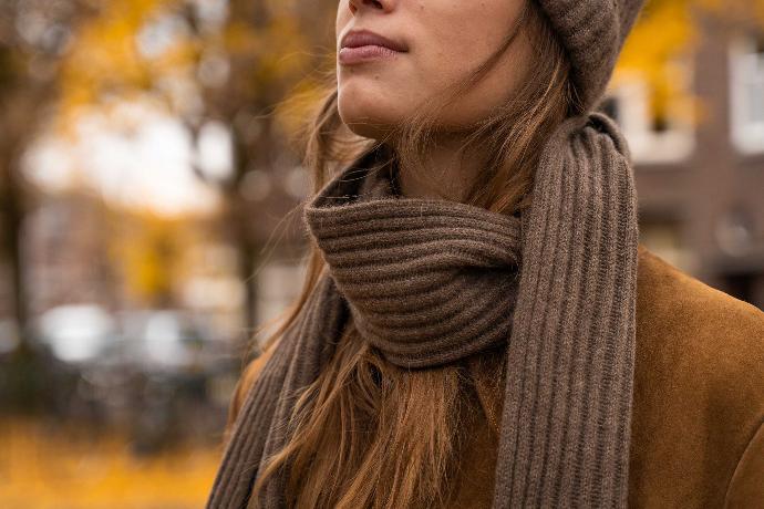 Model trägt yakbraunen Schal aus Yakwolle in herbstlicher Landschaft.