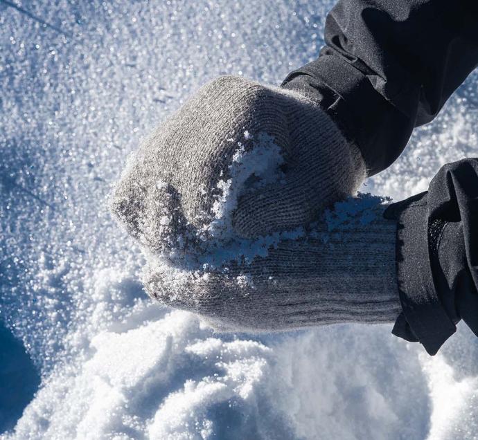 Graue Handschuhe formen Schneeball