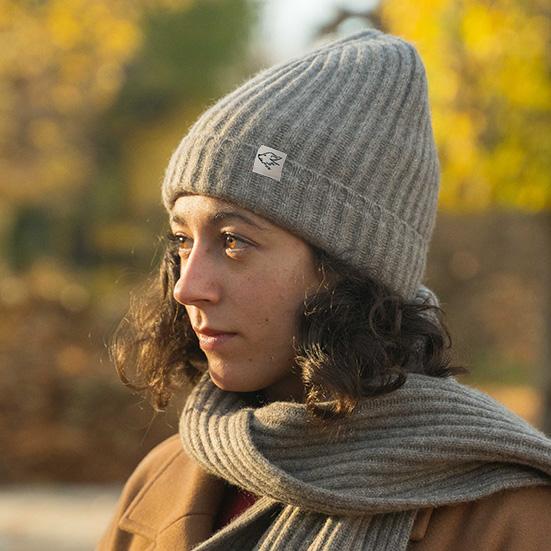 Woman wears grey woollen hat and grey woollen scarf
